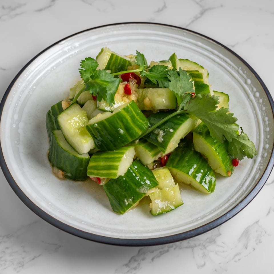 Nana Noodle House's smashed cucumber salad with chili and cilantro on a white plate.