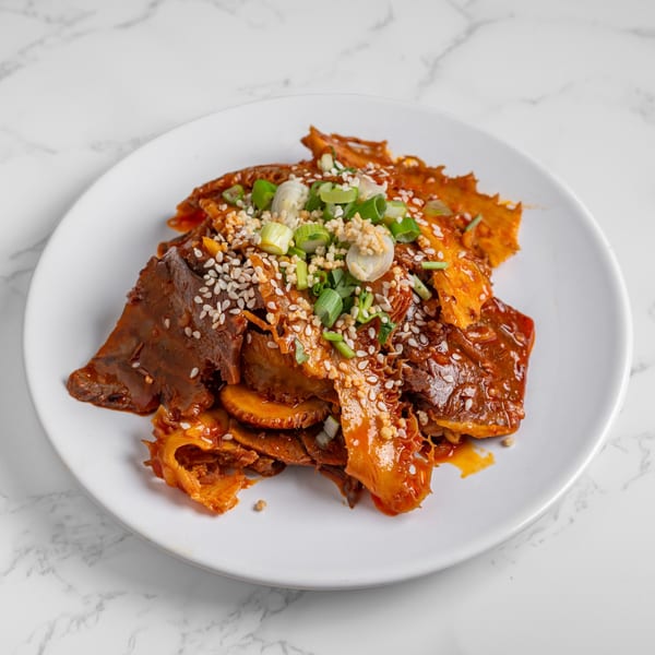 Nana Noodle House's spicy beef tripe and tendon, garnished with sesame seeds, garlic, and scallions.